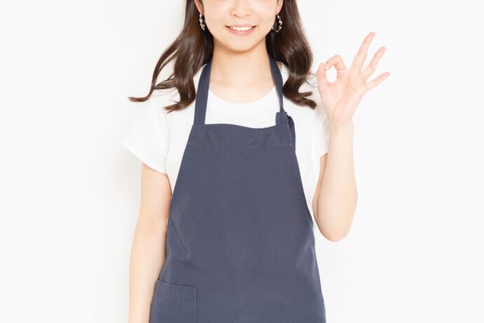 OKをするエプロン姿の女性