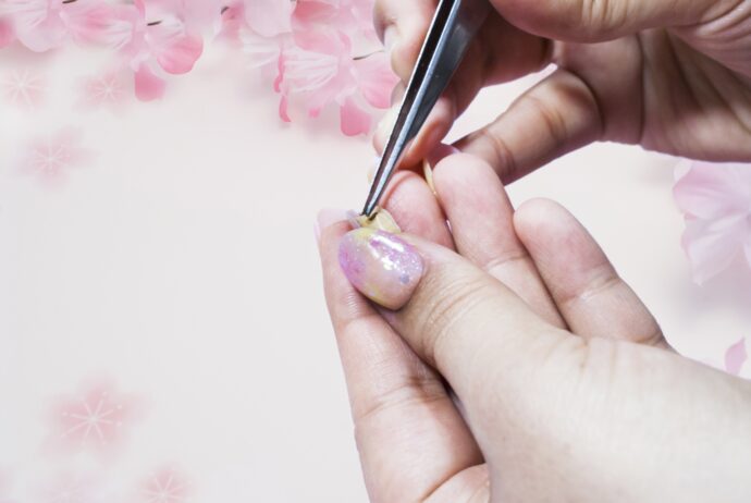 桜のネイルシールをピンセットで取る様子