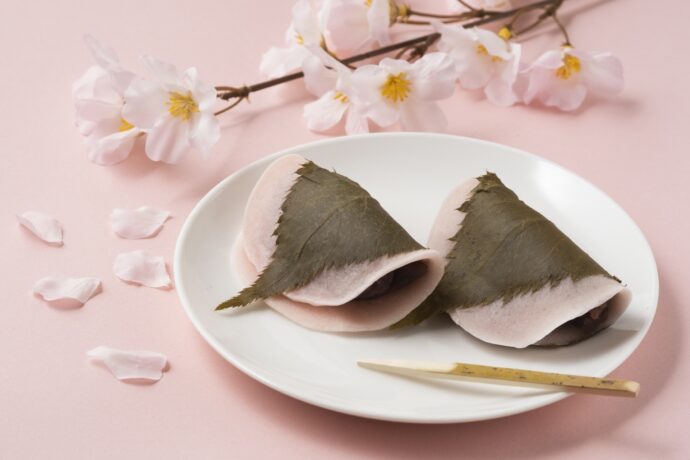 ピンクのバックに桜餅と桜の切り枝