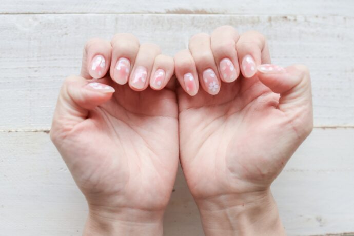 両手の桜ネイルを見せている手元の様子