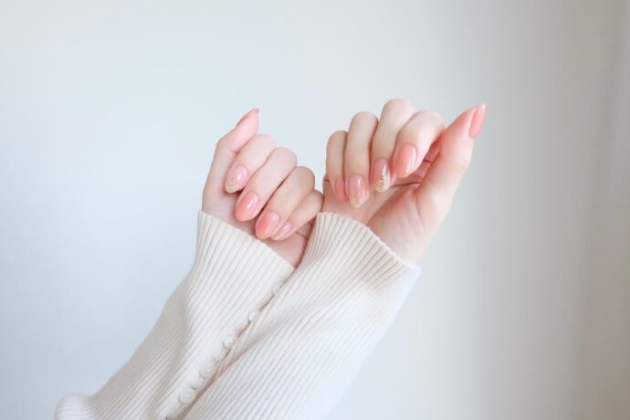白のニットと整えられた指先の様子