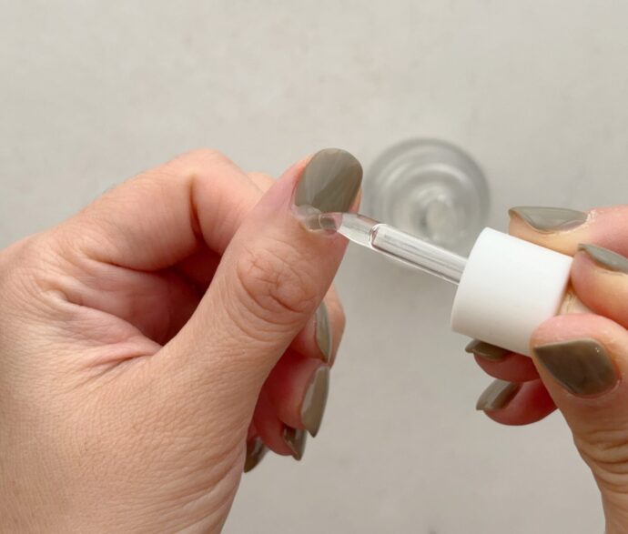 ネイルオイルを親指に塗る様子