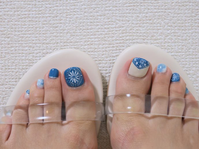 ブルーのフットネイルをした爪