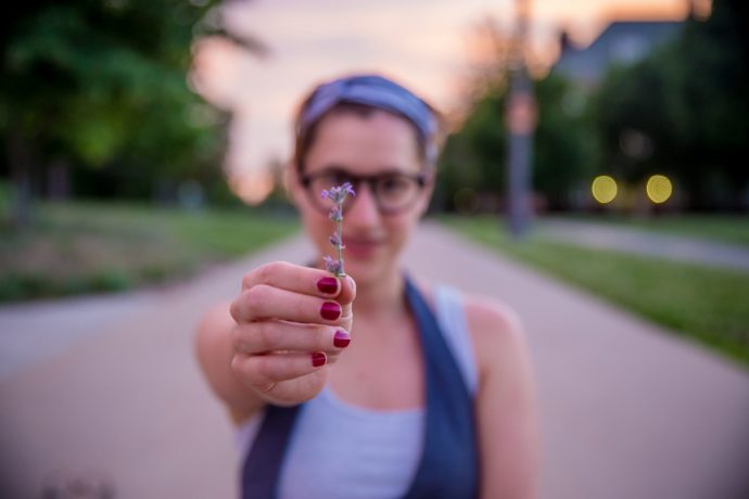 花を持った赤いネイルの女性の写真