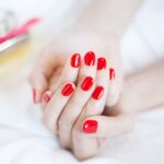 赤いネイルに美しい白い手
