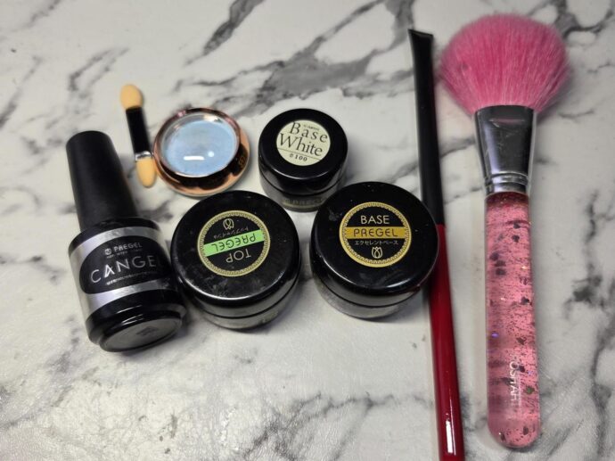 ノンワイプトップ、トップジェル、ベースジェル、ホワイトのカラージェル、オーロラパウダー、ジェルブラシ、ダストブラシが並んでいる