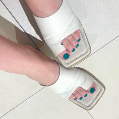 白いサンダルにグリーンのペディキュア