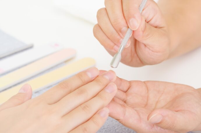 甘皮を押し上げてネイルケアをしている様子