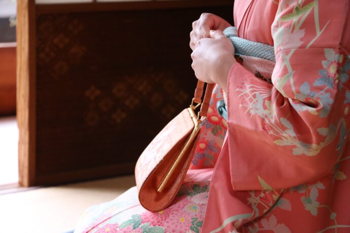 ピンクの振り袖にバックを持って座る