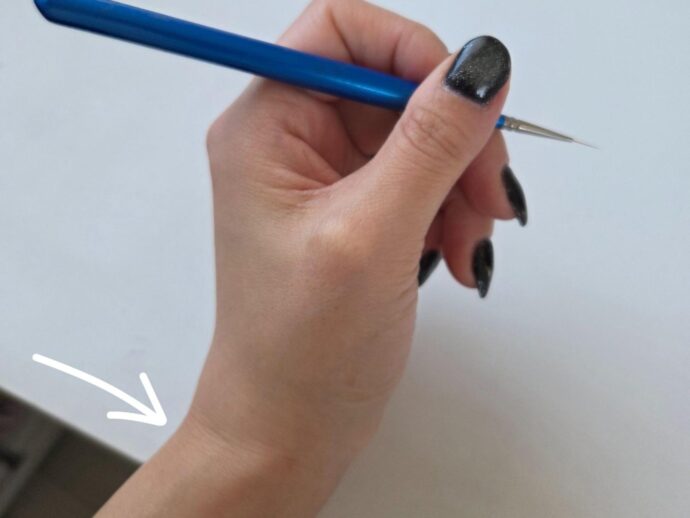 手首を固定してライナー筆を持っている様子