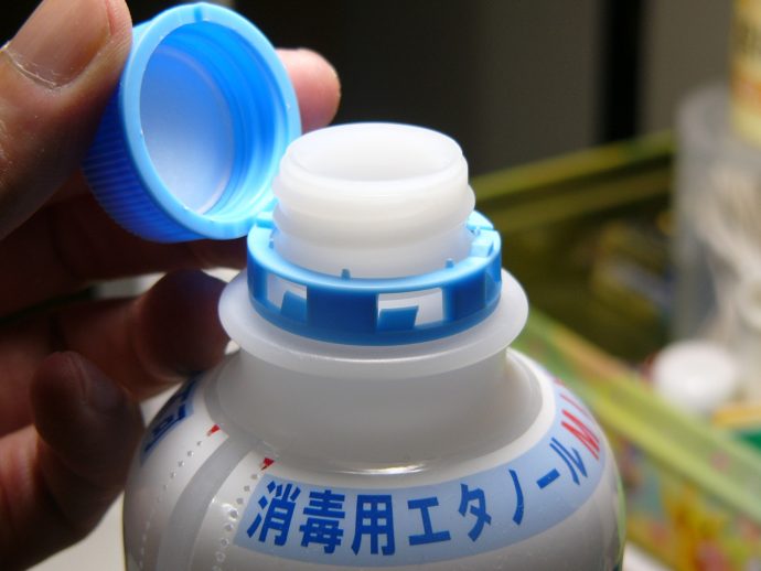 消毒用エタノールのボトルを開封する写真