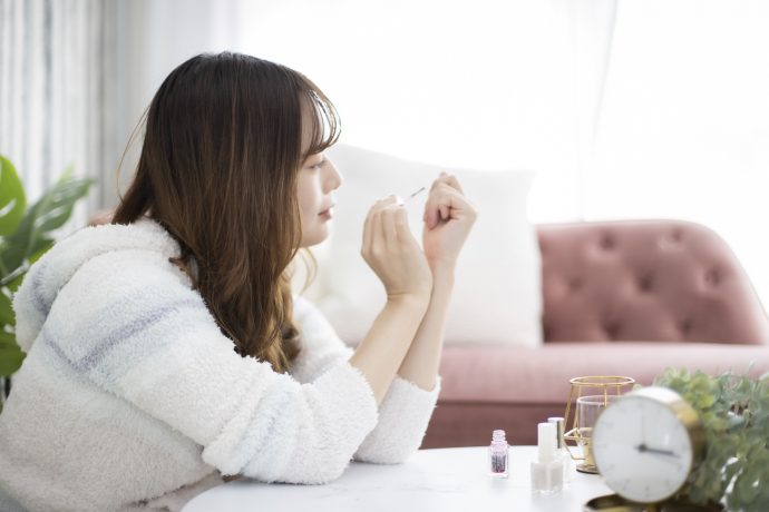 部屋の中でセルフネイルを楽しんでいる女性の写真