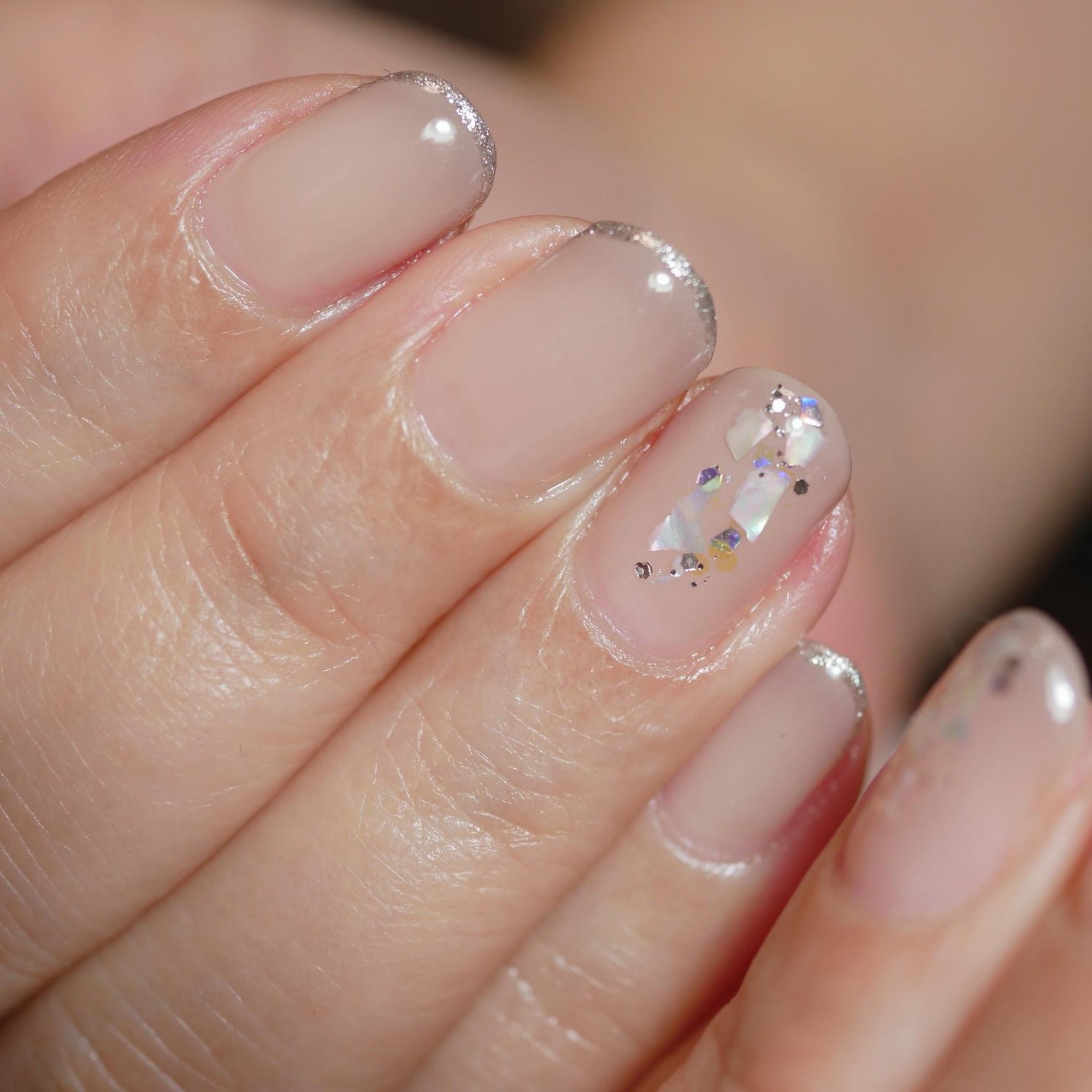 クリアなグレージュネイルをした手