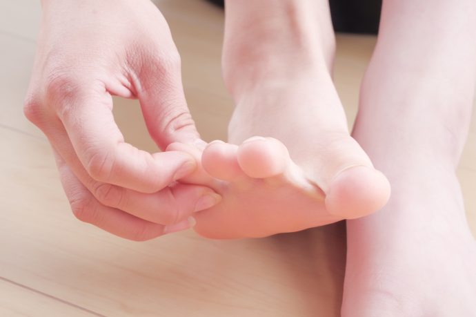 足の指を触っている女性の写真
