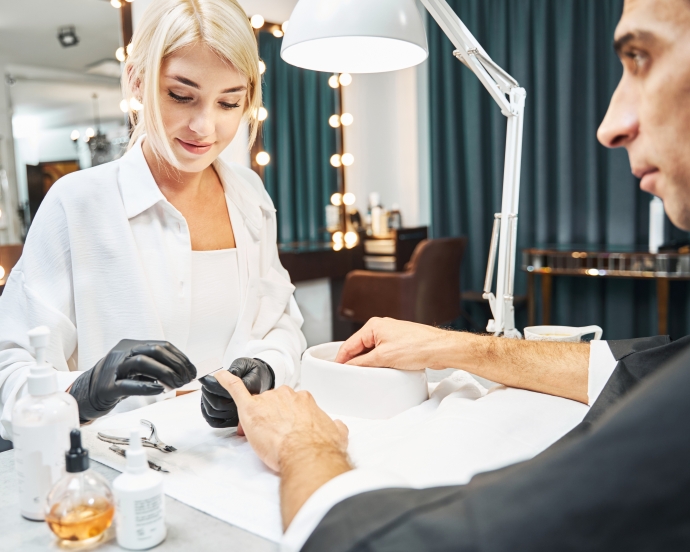 男性がネイルサロンで施術を受けている様子