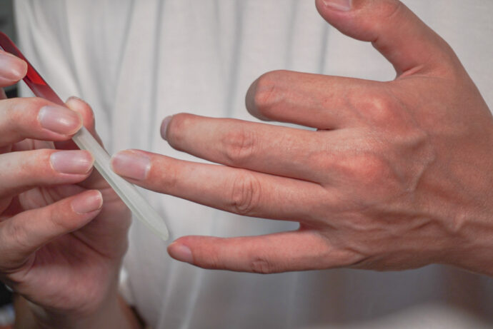 セルフでネイルケアをする男性の手元