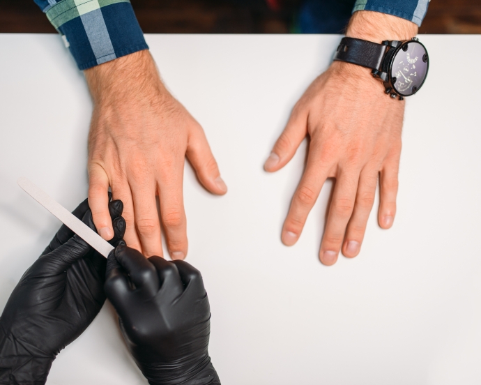 男性がネイルサロンで施術を受けている様子