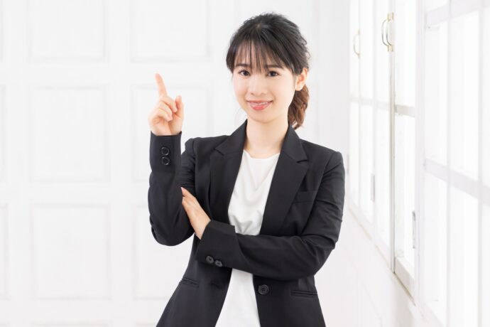 スーツの女性が指差しする様子
