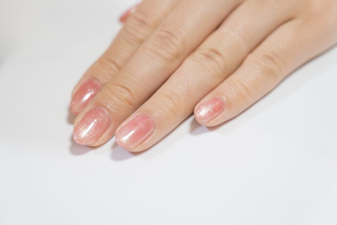 ピンクのマグネットネイルをした指先