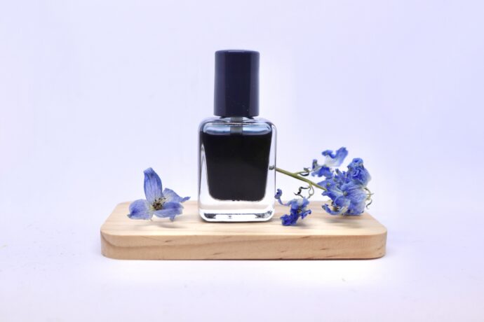 木のプレートに乗った黒マニキュア