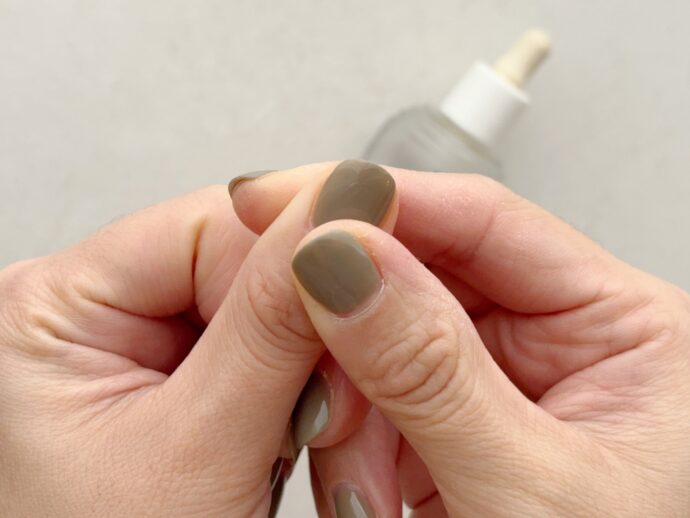ネイルオイルを爪の根元に馴染ませている様子