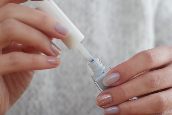セルフネイルでマニキュアを塗ろうとしている手元