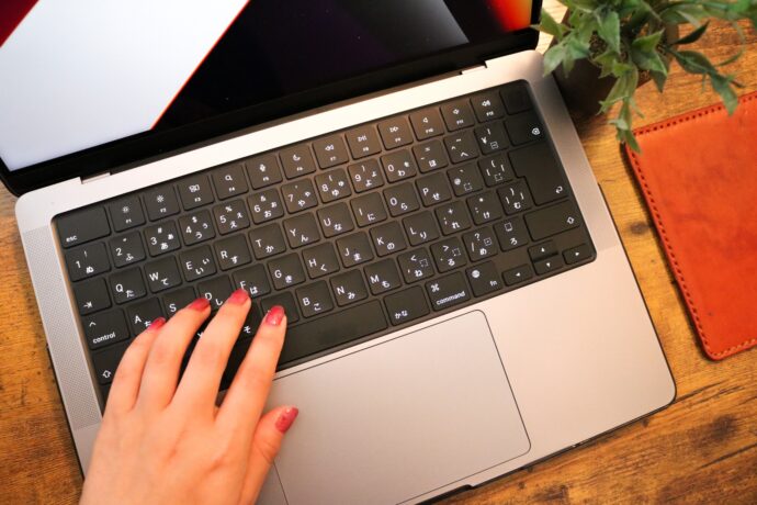 ネイルをした手元とパソコンを操作する様子