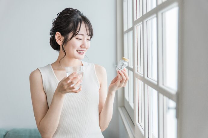 サプリメントを持つ女性
