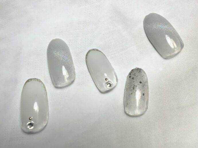 ホワイトのベースカラーにオーロラのマグネットネイルを重ねる