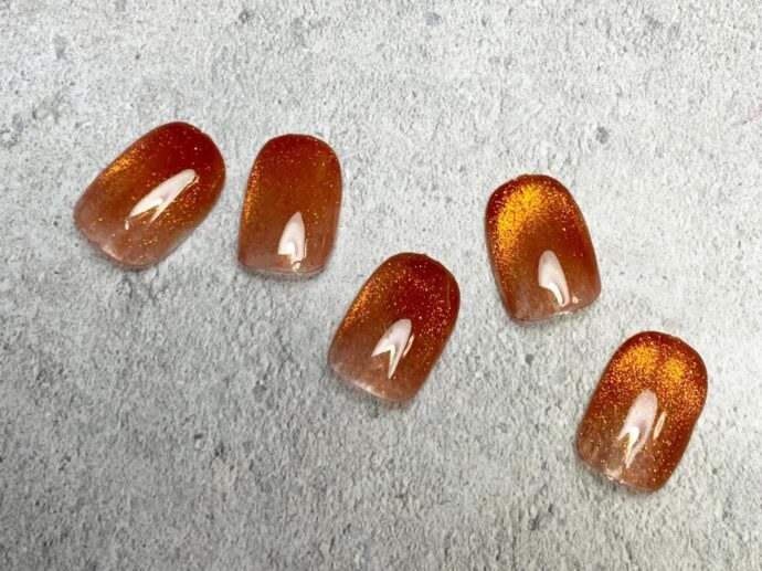 テラコッタのベースカラーにオレンジのマグネットネイルを重ねたもの