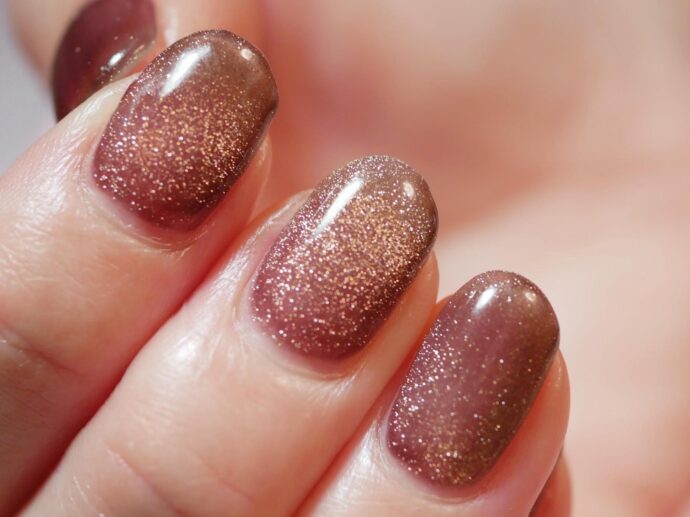 ダークブラウンのベースカラーにゴールドのマグネットネイルを重ねたもの