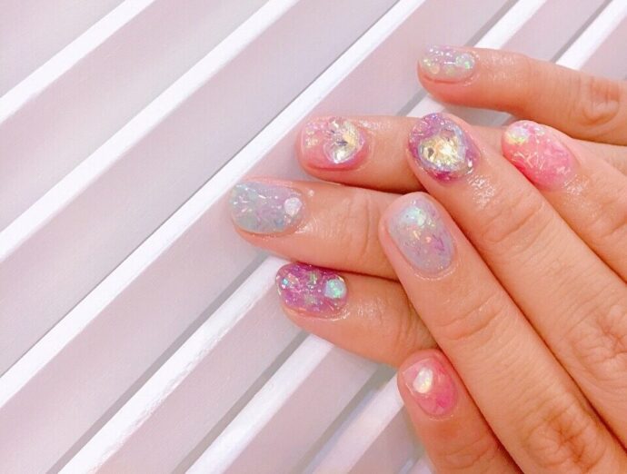 カラフルなラメネイルをした手