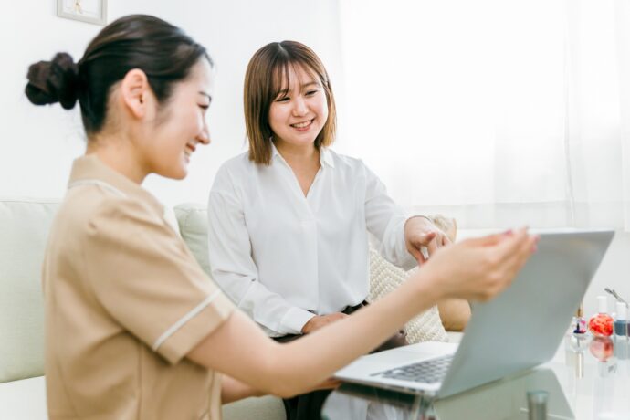 お客様にカウンセリング中のネイリスト