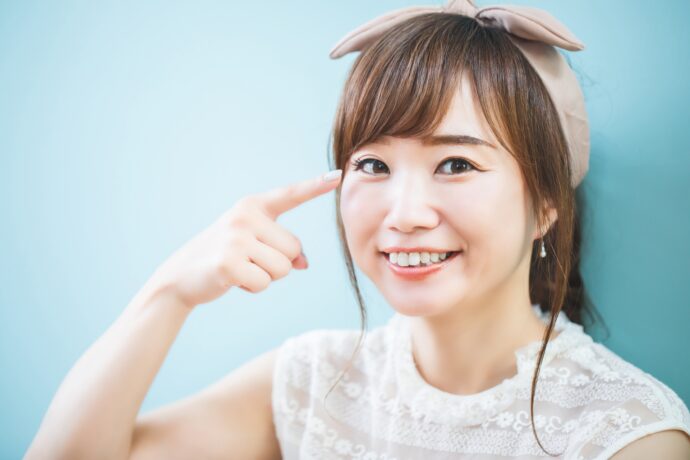 目を指さす女性の画像
