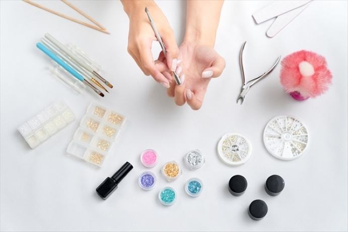 ネイルケア中の手元とネイル道具が並んでいる