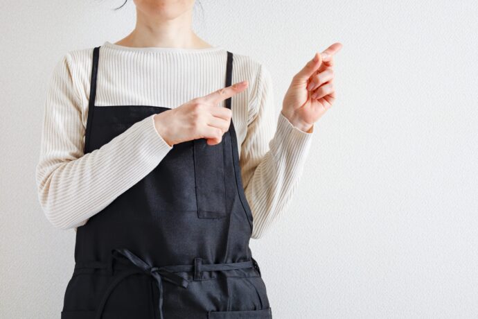 両手で指を指す女性