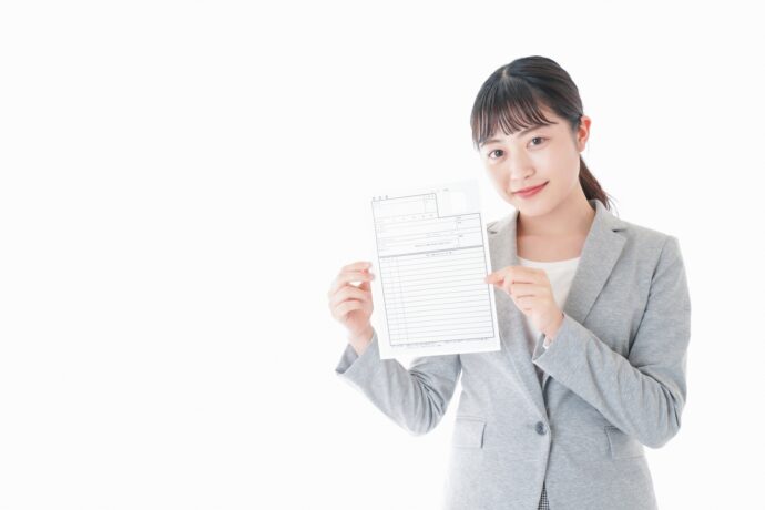 履歴書を持つグレーのスーツの笑顔の女性