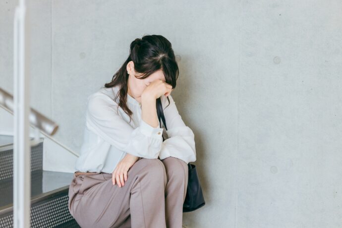 一人階段でうなだれる女性の様子