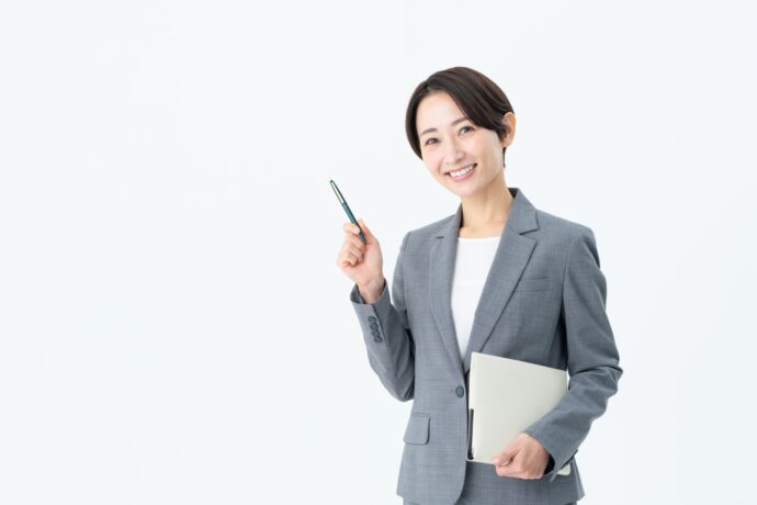 ポイントを指すグレースーツの女性