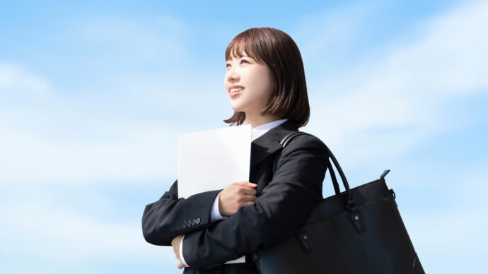 リクルートスーツで履歴書を抱える新卒女性