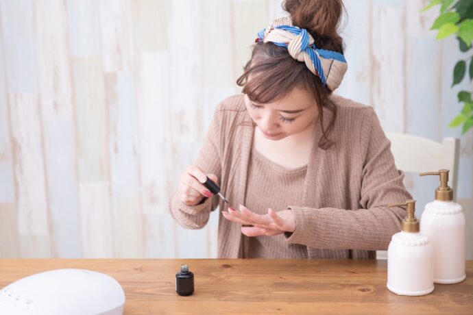 ルームウェアでマニキュアを塗る女性の画像