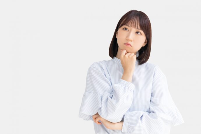 顎に手を当てて考える女性