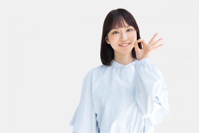 左手でokサインをする女性