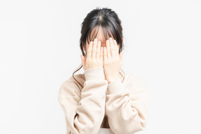 両手で顔を覆う女性