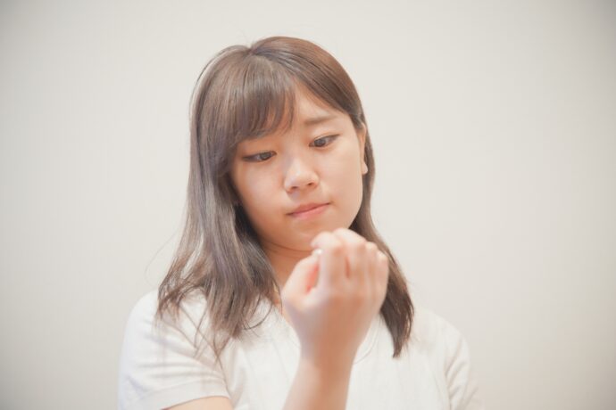 ネイルを気にしている女性の画像