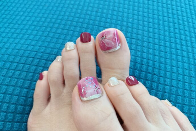 ピンクのフットネイルチップを付けた画像