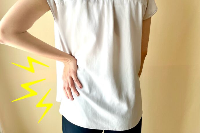 腰痛を気にする女性の後ろ姿