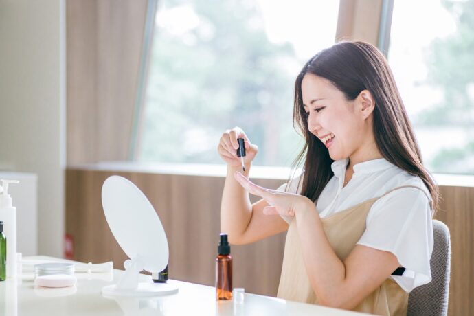 ネイルオイルを塗る笑顔の女性