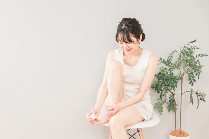 椅子に座ってフットネイルケアをする女性