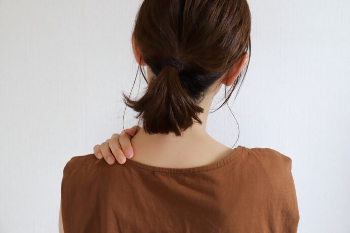 肩こりを気にする女性の後ろ姿